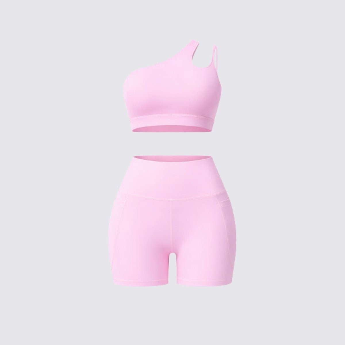 Front flatlay display of a pink two piece yoga outfit featuring a one shoulder workout top and high rise athletic shorts