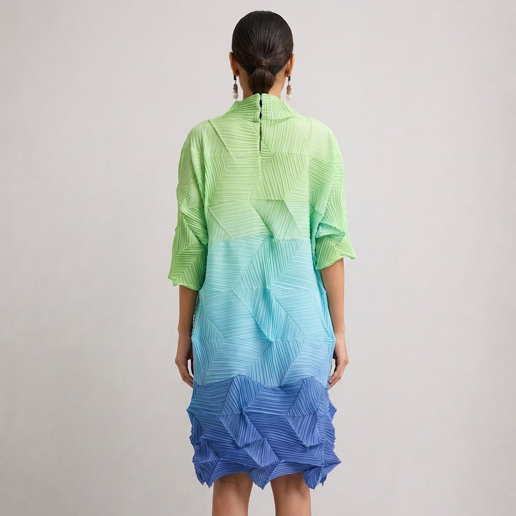 Back view of the Kouvr structural plisse colorblock dress showing the relaxed fit, back neckline seam, and vibrant blue hem.