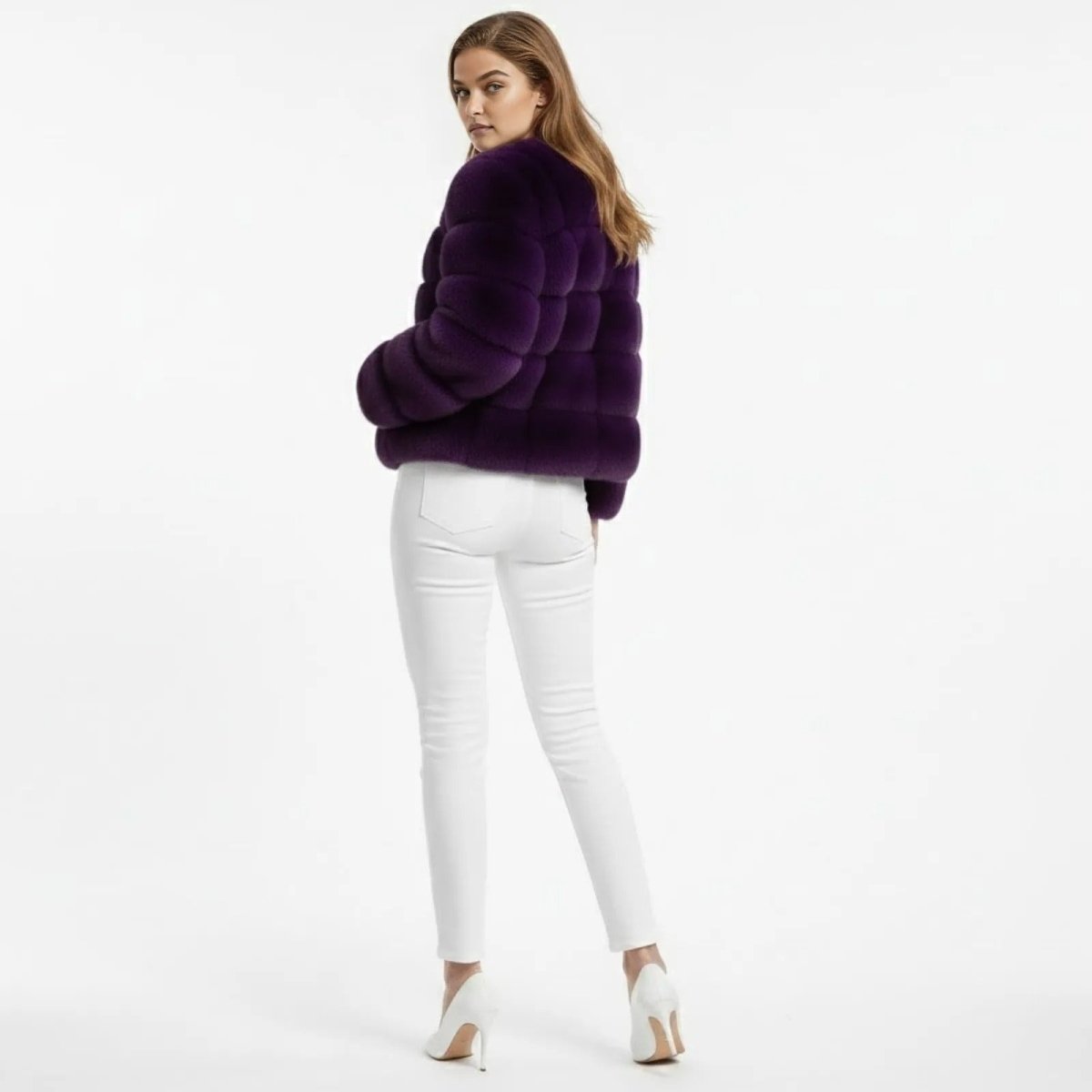 Back view of a model wearing the Kouvr Fashion violet purple faux fur jacket, highlighting the horizontal panel details.

