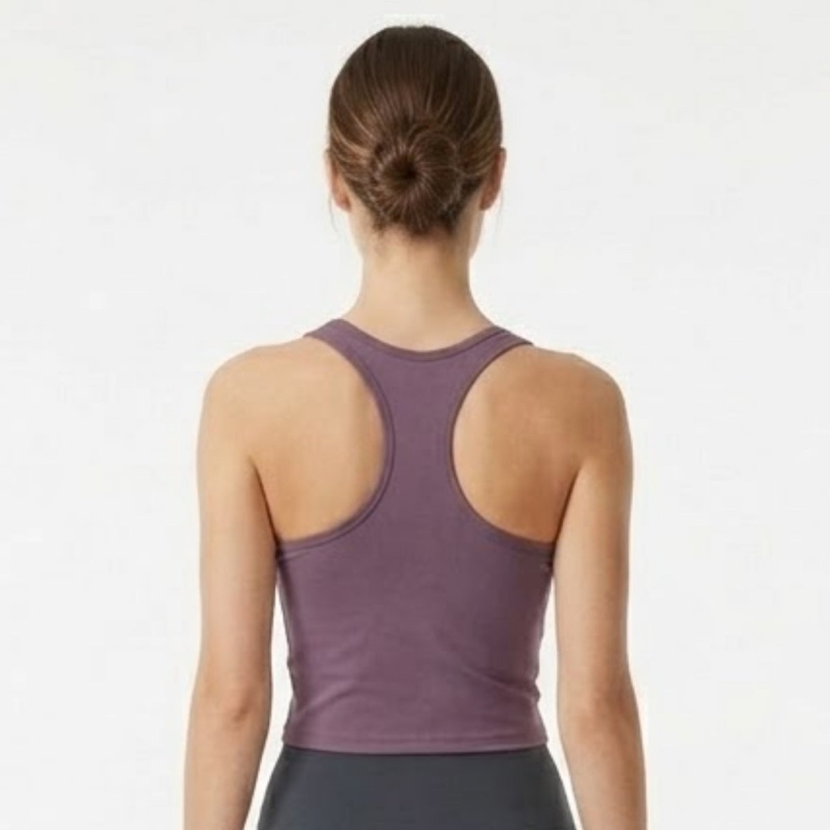 Back view of woman wearing Kouvr plum racerback athletic sports bra top.