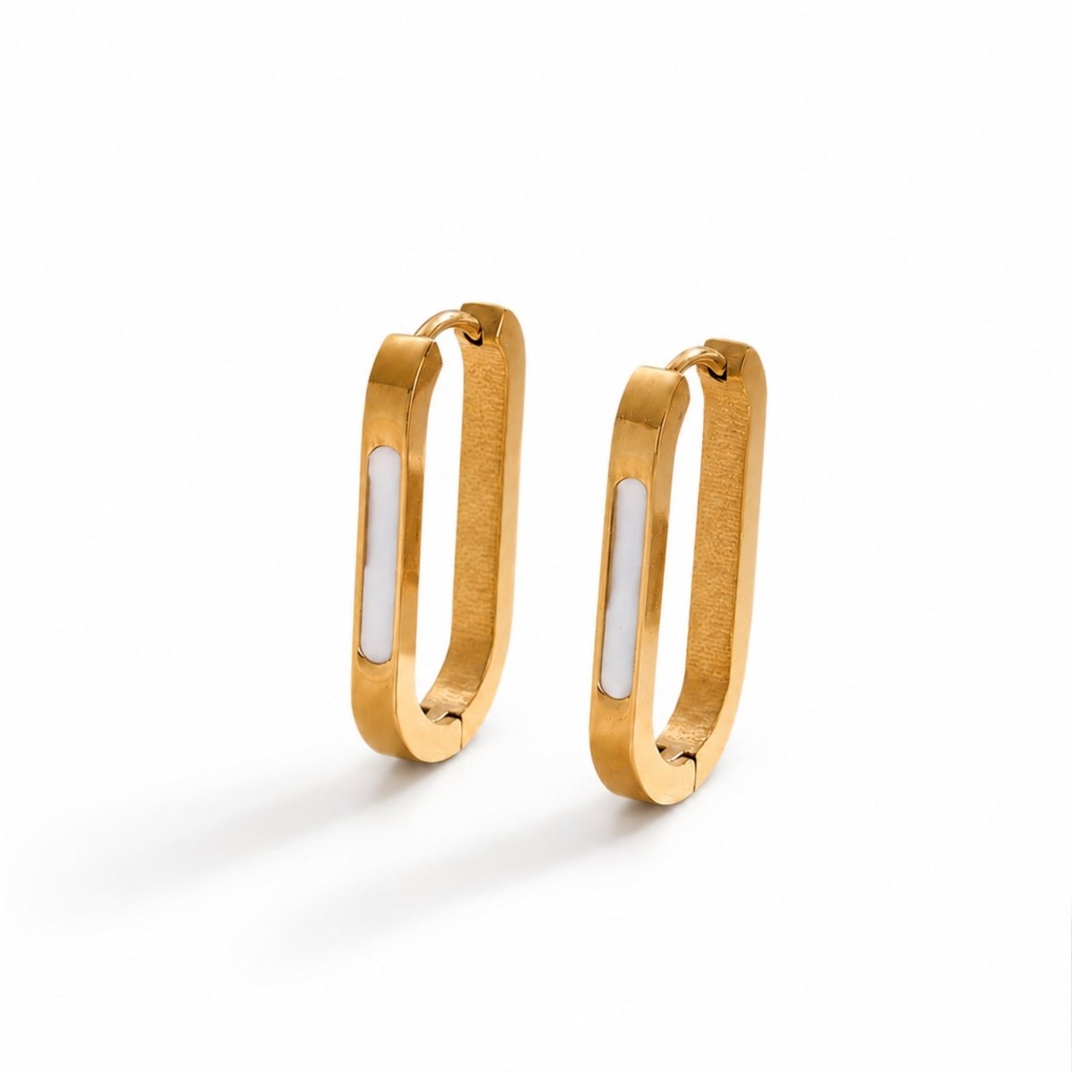 Close up studio shot of luxury rectangular gold hoop earrings featuring a modern white enamel inlay on a clean white background.