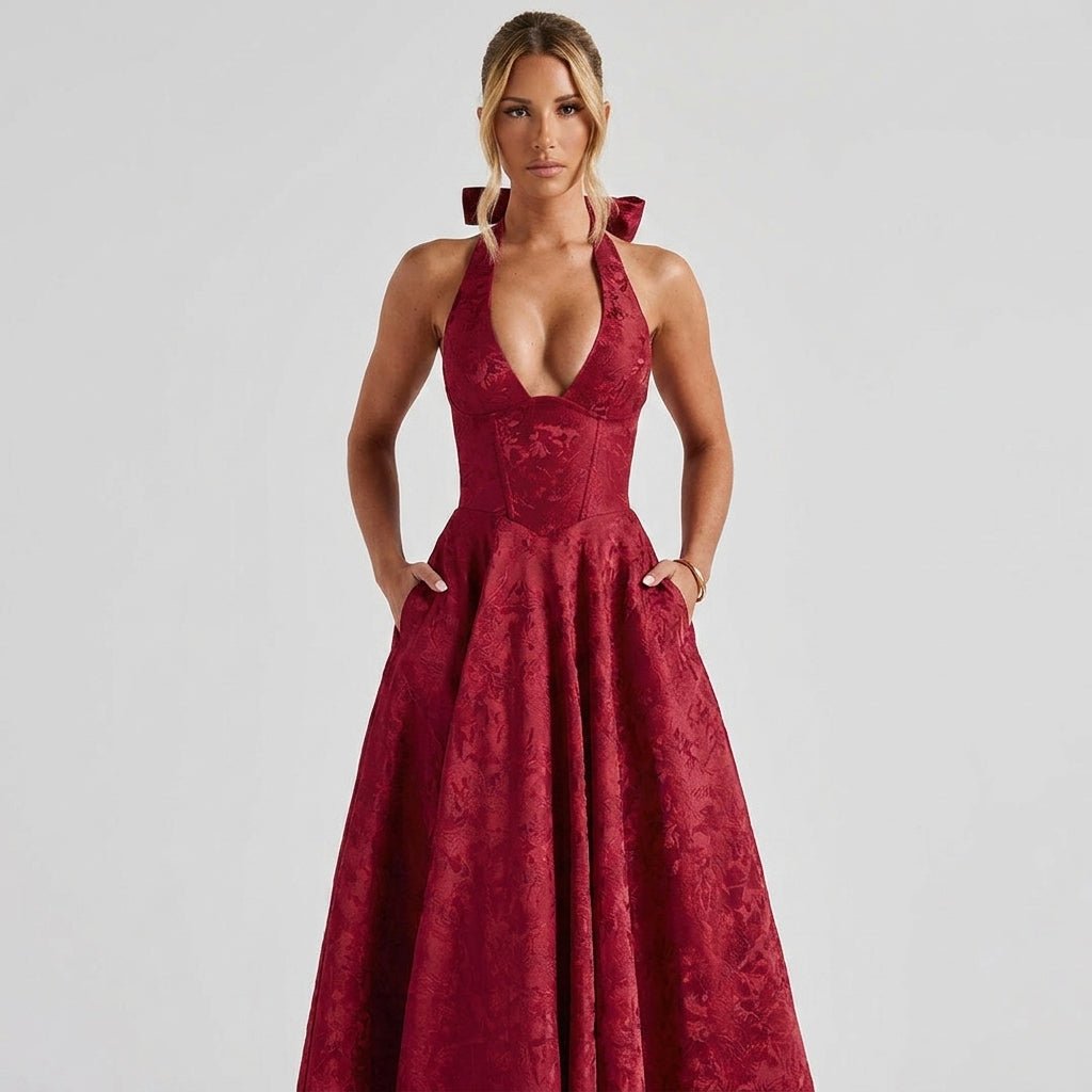 Woman modeling the Kouvr burgundy floral textured A-line midi dress with her hands in the functional hidden side pockets.