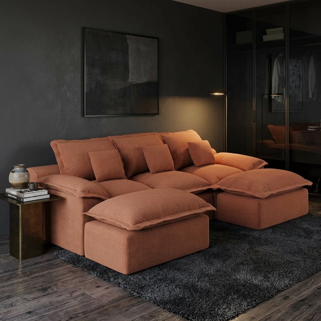 Industrial-style living room with an oversized rust-colored modular sectional sofa against an exposed brick wall.