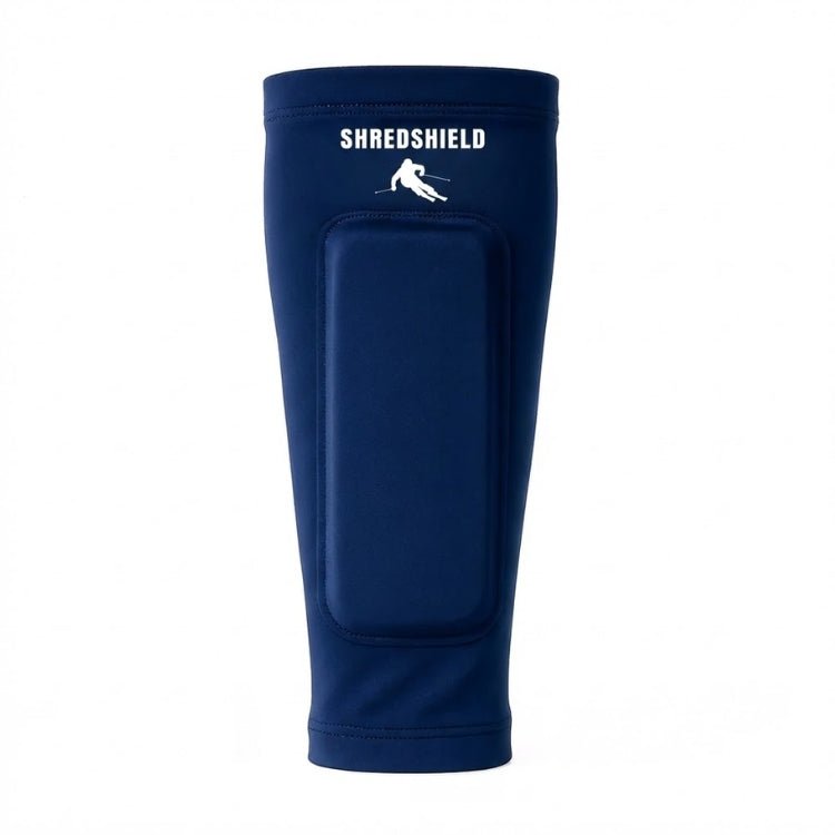 Front view of the navy blue ShredShield ski shin guard with a matching blue gel protective pad and white logo, against a plain white background.