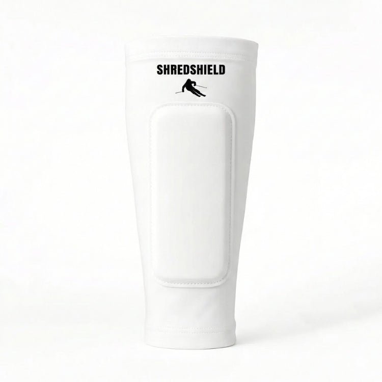 Front view of the white ShredShield ski shin guard with a matching white gel protective pad and black logo, against a plain white background.