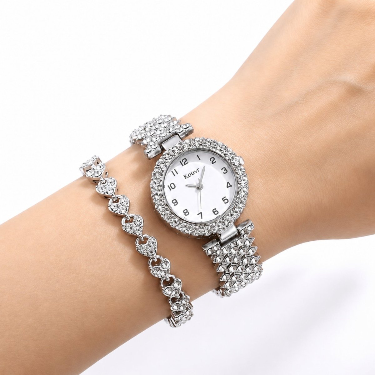 Close up of a woman's wrist wearing the elegant Kouvr silver crystal watch and interlocking heart design rhinestone bracelet.