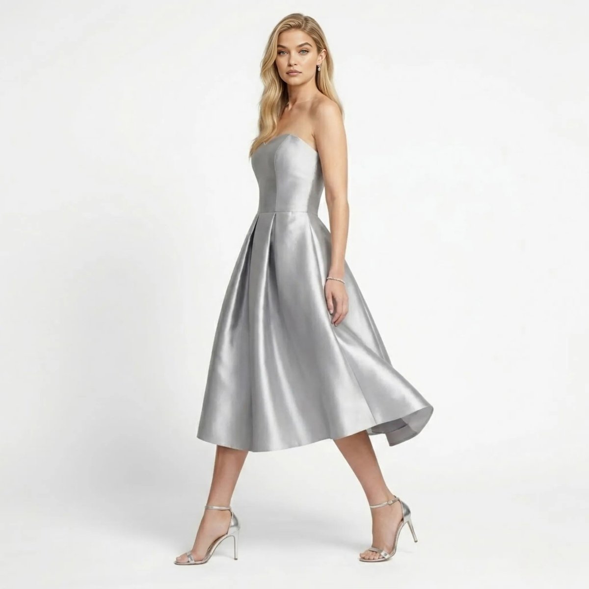 Side angle view of a blonde model walking in a silver A-line structured formal dress with metallic heels.