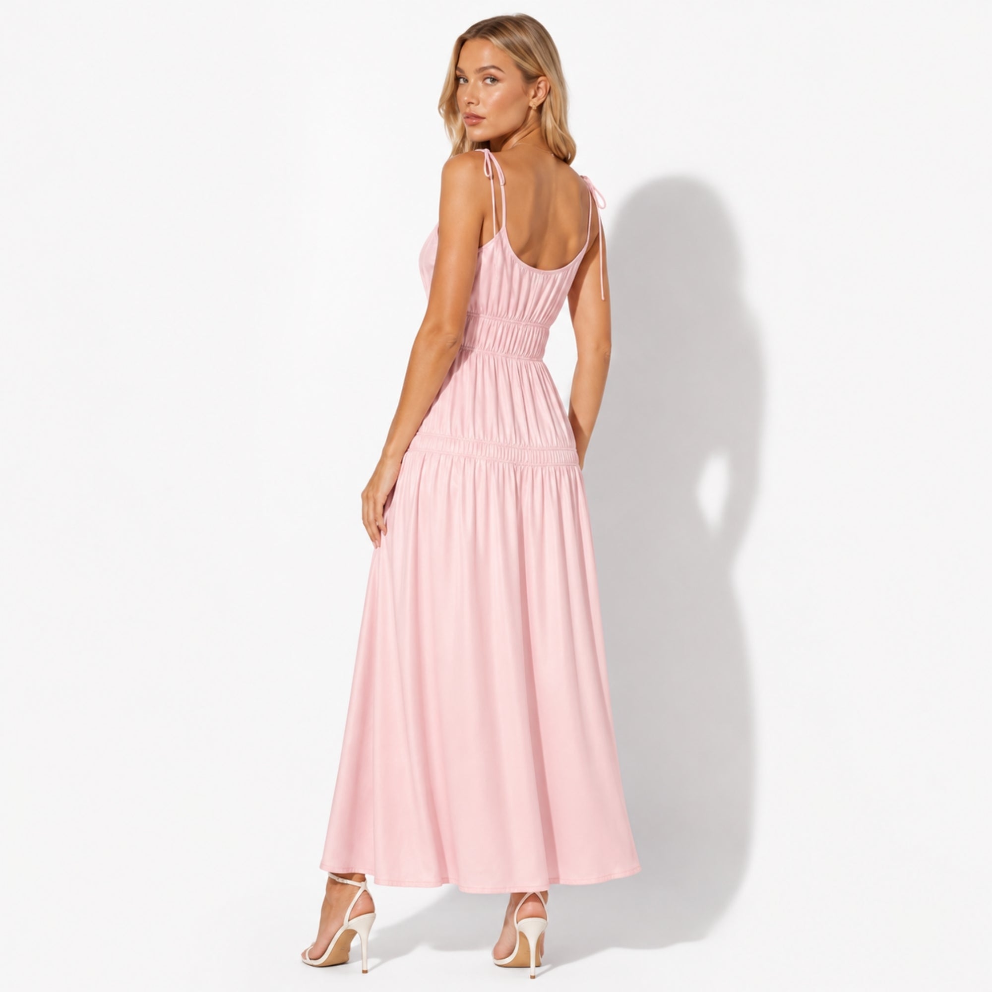 Back view of light pink tiered maxi dress highlighting delicate adjustable tie straps
