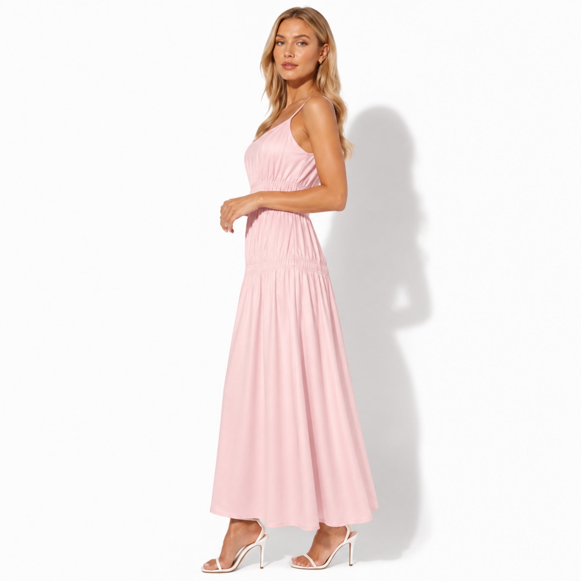 Side profile of a light pink flowy maxi sundress showing wide smocked bodice details