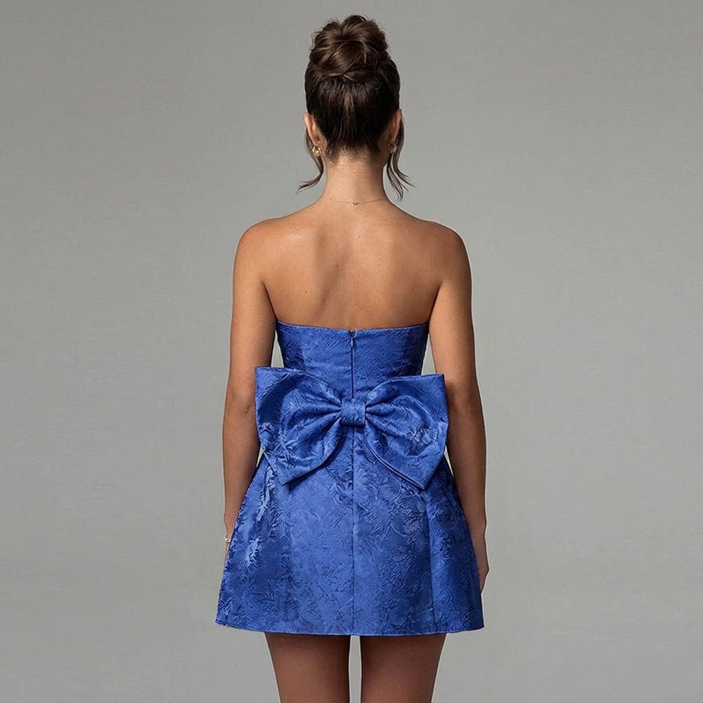 Back view of Kouvr dark blue party dress highlighting the oversized statement bow and invisible zipper detail.
