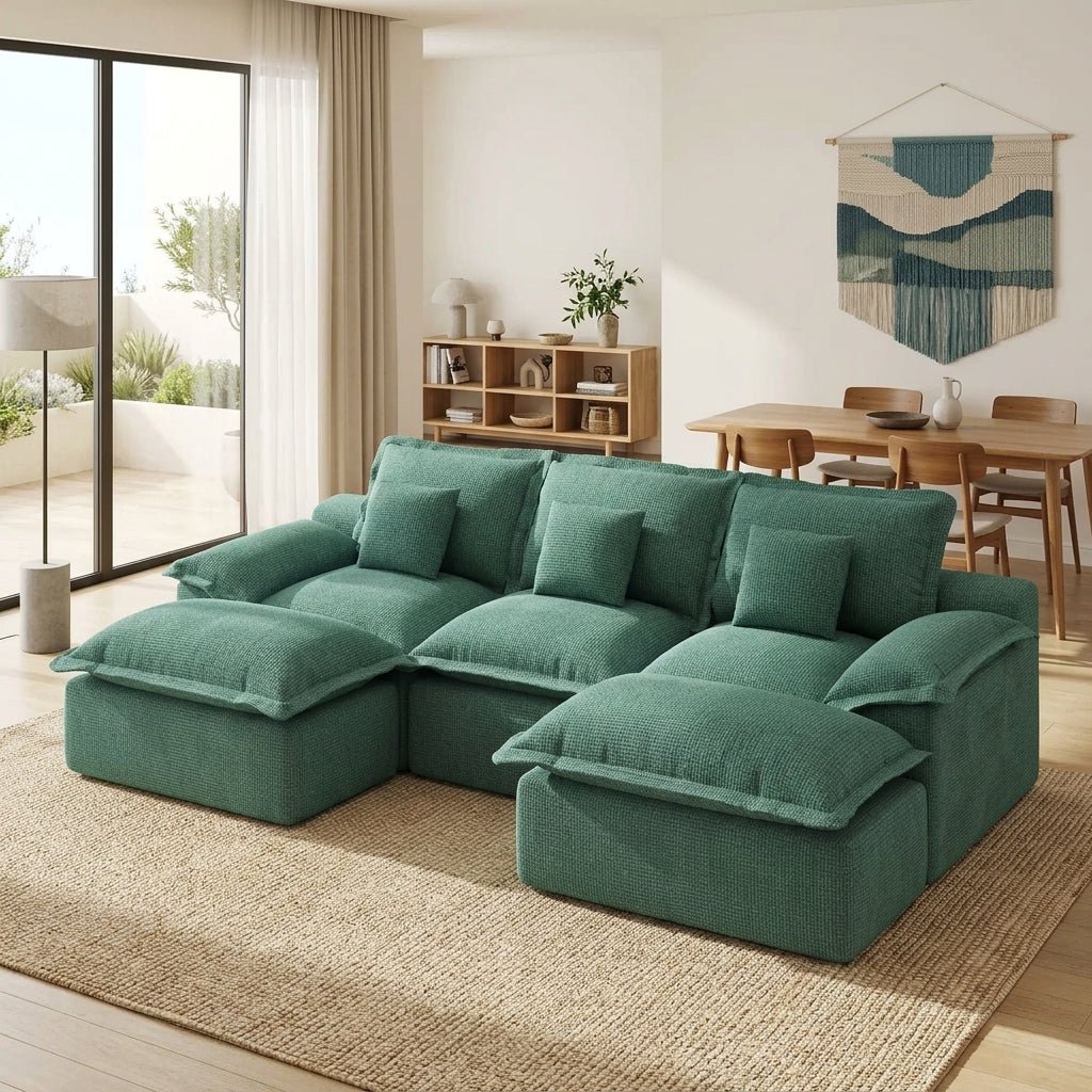 A woman relaxing with a cup of tea and a book on a plush teal cloud-style modular sofa.