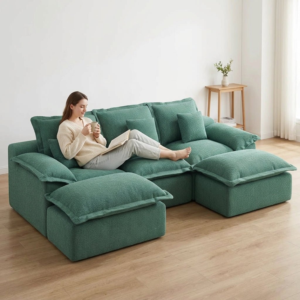 Modern teal modular couch styled with a neutral throw blanket in a sophisticated apartment with dark grey walls.