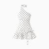High-quality studio shot of a white one-shoulder mini dress with black polka dots, a side bow, and a ruffle hem.