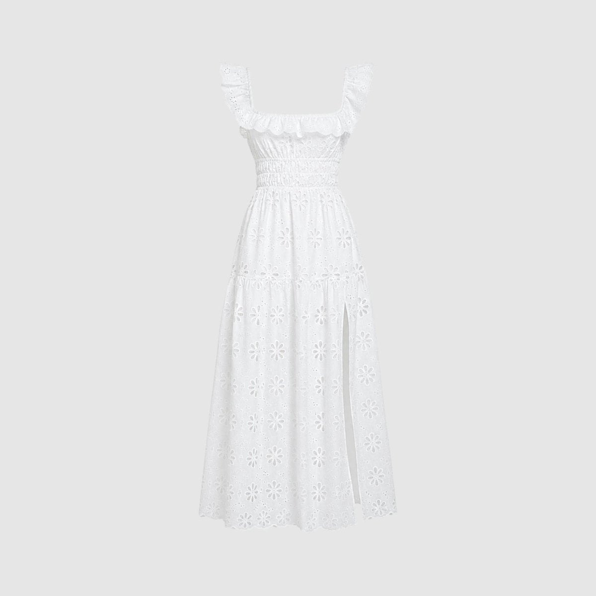  Studio shot of white smocked eyelet maxi dress with ruffled straps and side slit on a light grey background.