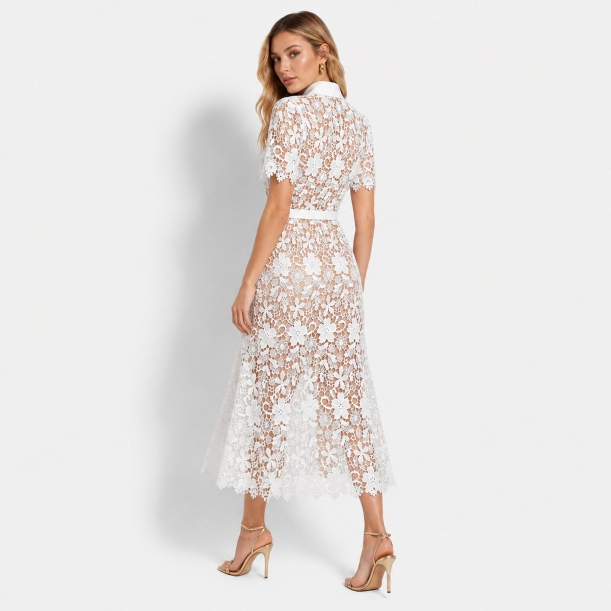 Back view of the Kouvr white floral lace A-line dress showing the tailored fit, scalloped hemline, and delicate semi-sheer lace details.