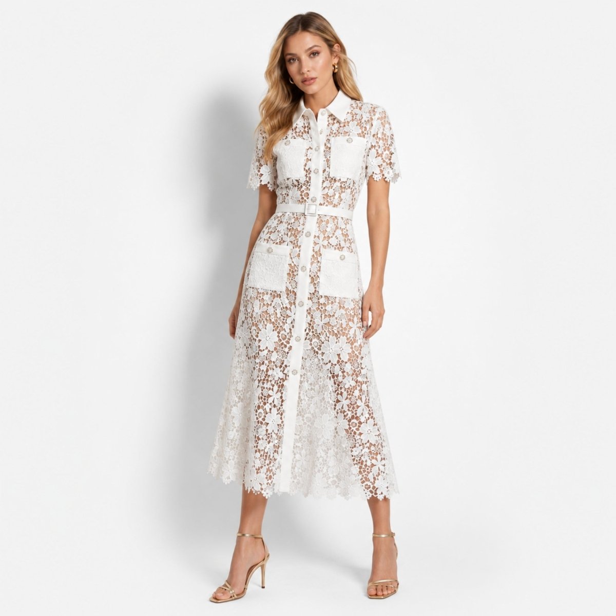 Woman wearing an elegant white floral lace button down midi shirt dress with belt by Kouvr, standing in a sophisticated pose against a white background.