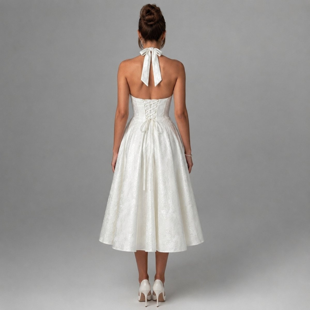 Back view of the Kouvr white bridal rehearsal dress highlighting the adjustable lace-up corset back and elegant halter tie bow.
