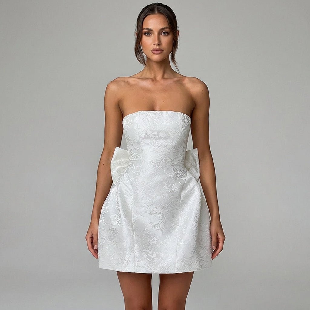 Close up portrait of white strapless structured mini dress showing woven floral jacquard fabric details