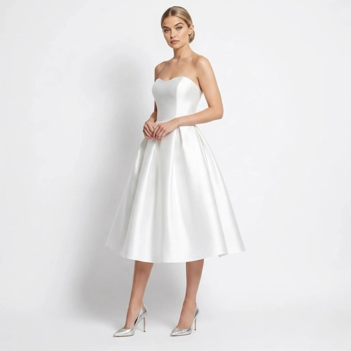 Side angle view of woman modeling a white strapless sweetheart midi dress in satin finish.