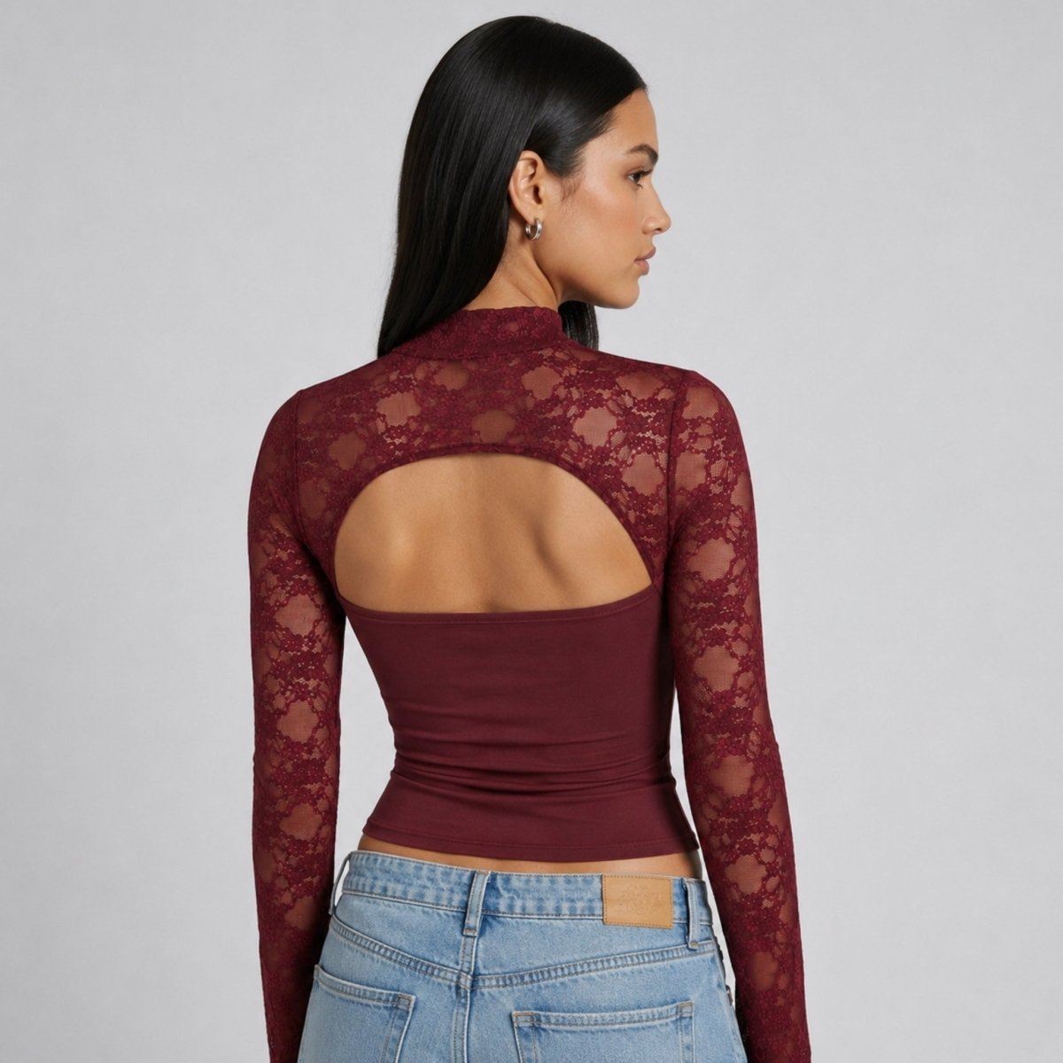 Back view of Kouvr wine red sheer lace long sleeve top showing large open back cut-out on model