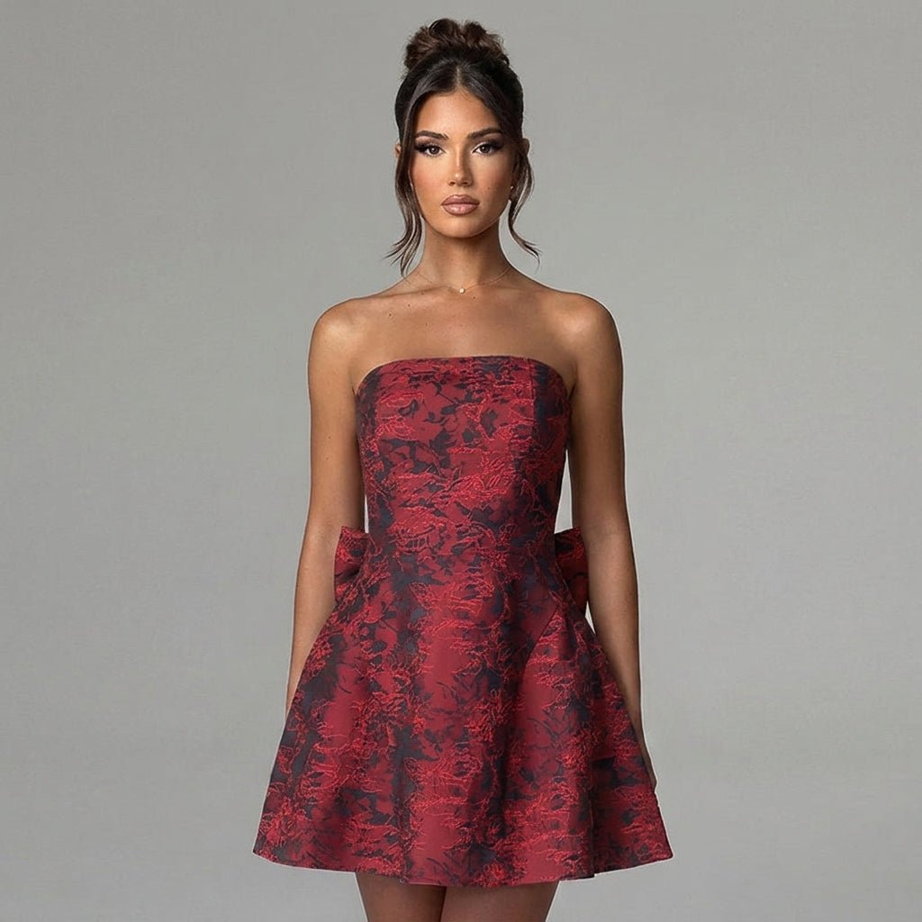 Close up view of the structured bodice and rich tactile floral jacquard fabric on a red strapless party dress.