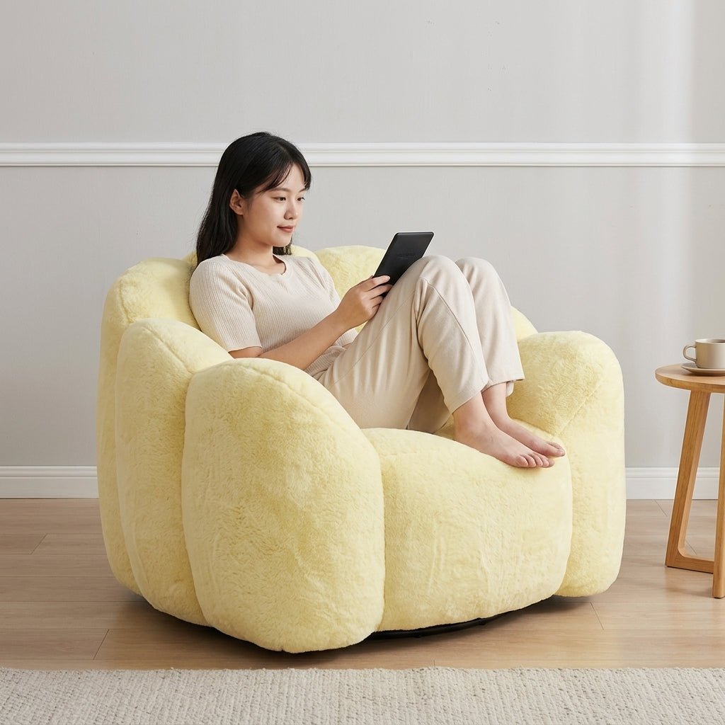 Young woman sitting comfortably with crossed legs reading a tablet on a modern yellow scalloped lounge armchair.