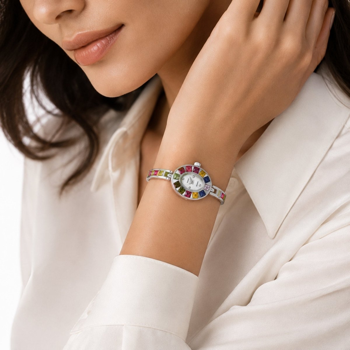 Close up of a woman wearing a white silk shirt styling the Kouvr vintage rainbow rhinestone jewelry watch gracefully on her wrist