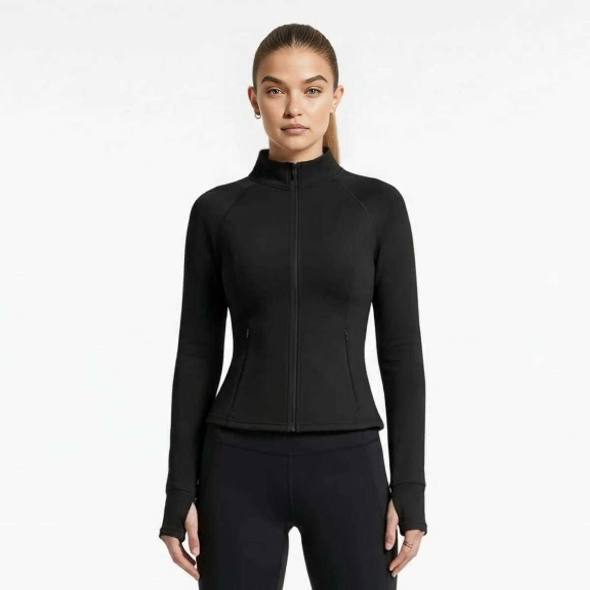 Woman wearing Kouvr premium black fitted zip-up activewear jacket with mock neck and thumbholes, front view.