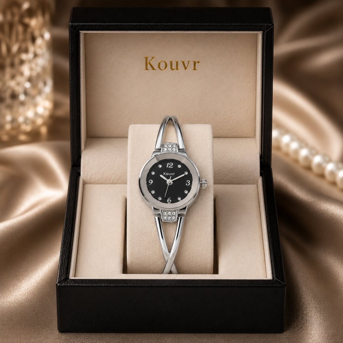 Kouvr elegant women's silver bangle watch with a contrasting black dial and crystal accents displayed in a luxury presentation gift box.