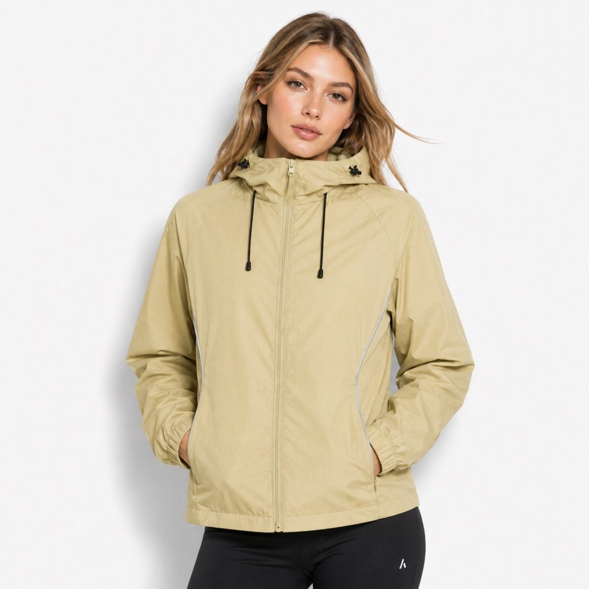 Woman modeling the versatile unisex light army green water-resistant zip-up rain shell jacket by Kouvr.