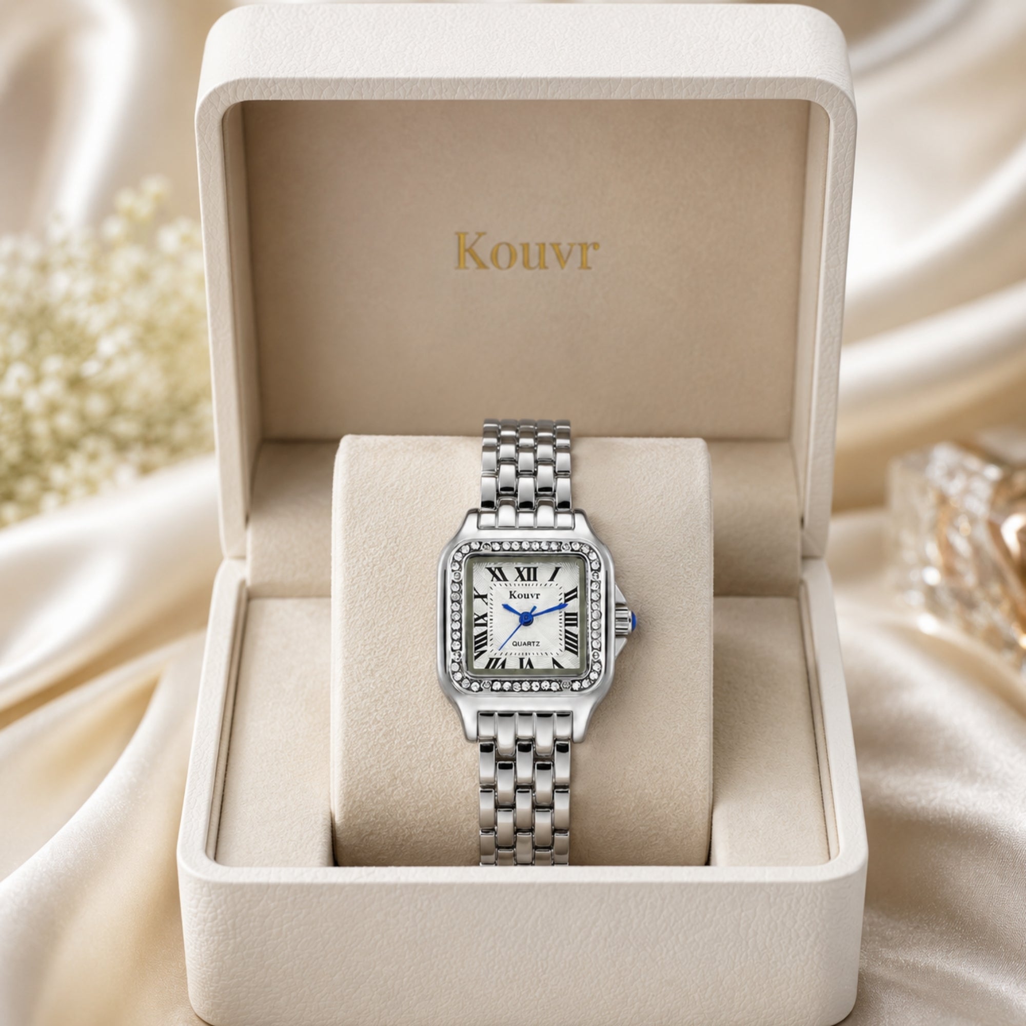 Silver tone women's luxury quartz watch by Kouvr with crystal embellished bezel presented in an elegant white leather gift box.