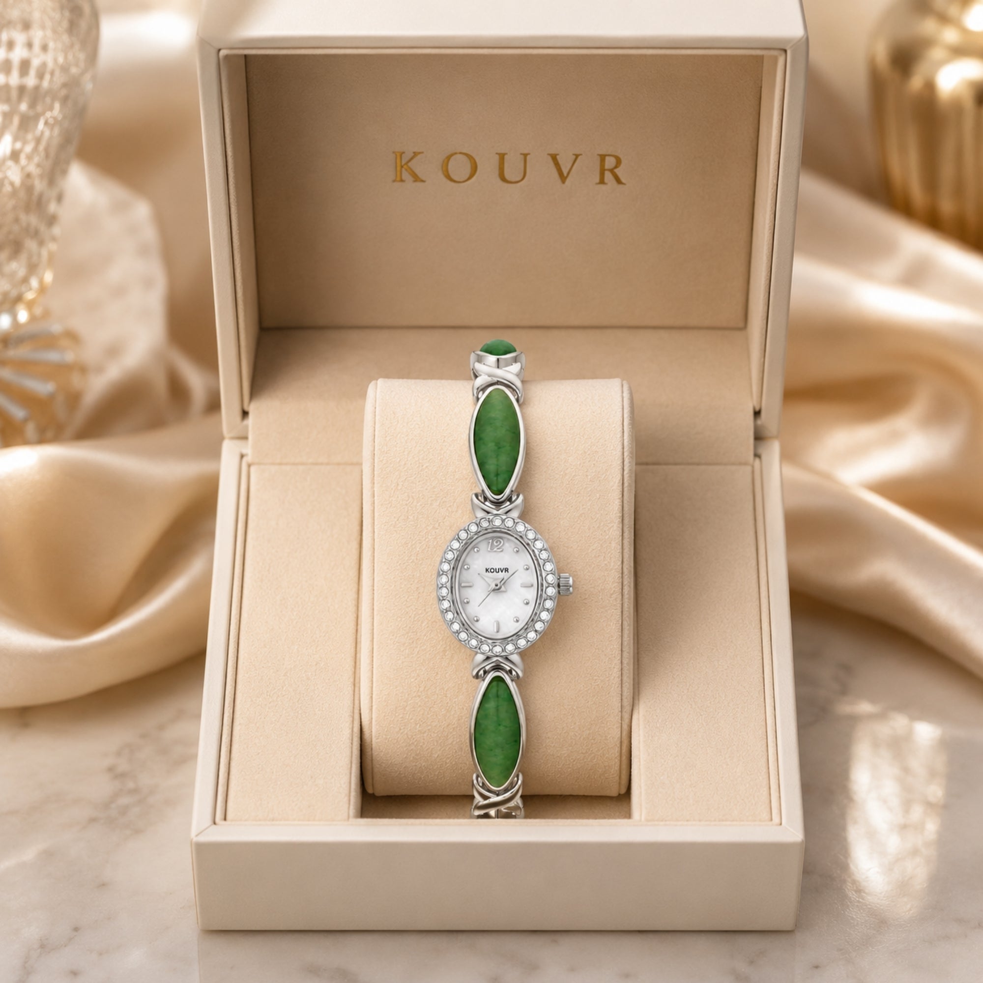 Flat lay studio shot of a women's silver stainless steel watch with green oval jade gemstone links and a crystal halo bezel.