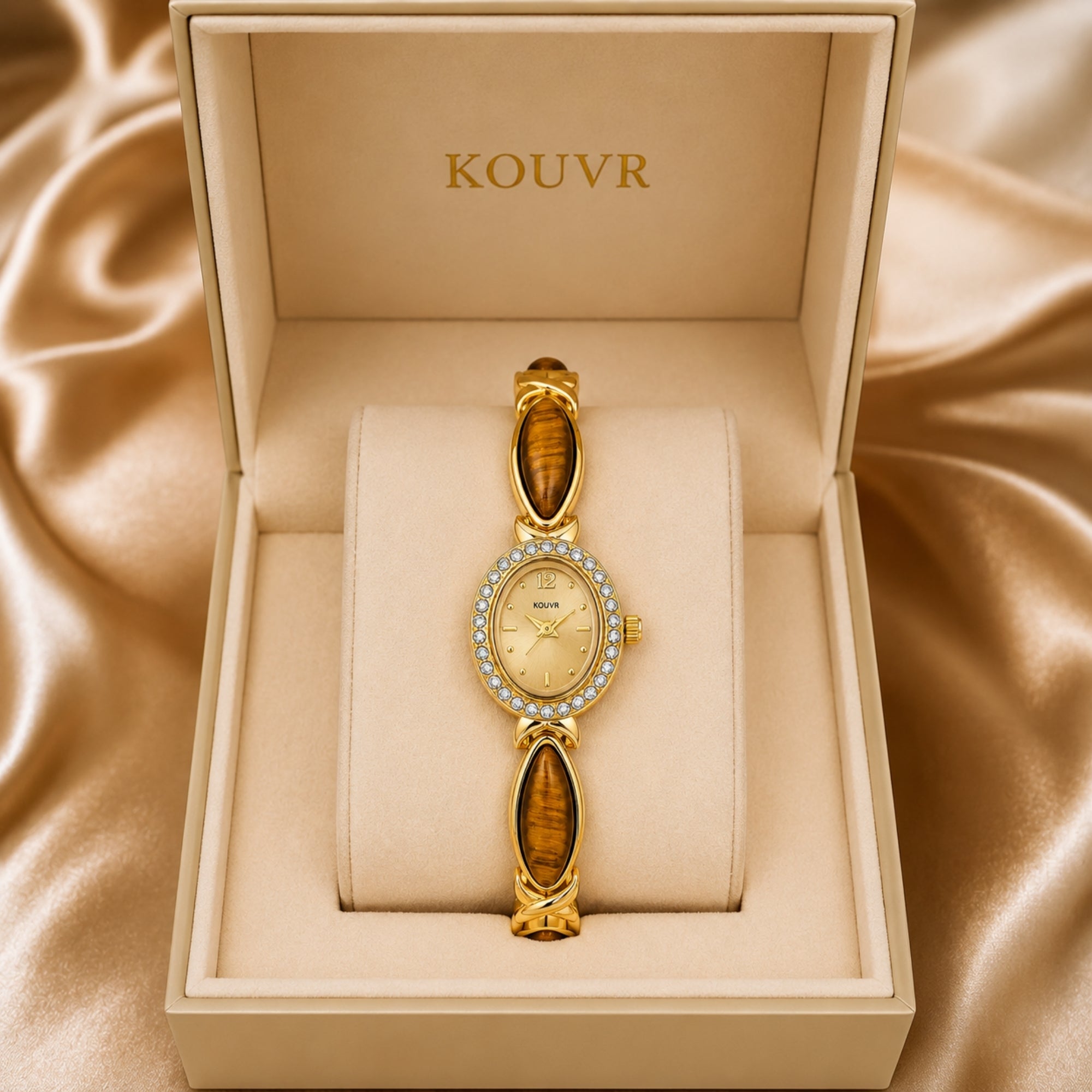 Luxury women's vintage style gold watch with brown tiger eye gemstone links resting on a pillow in a Kouvr presentation box.