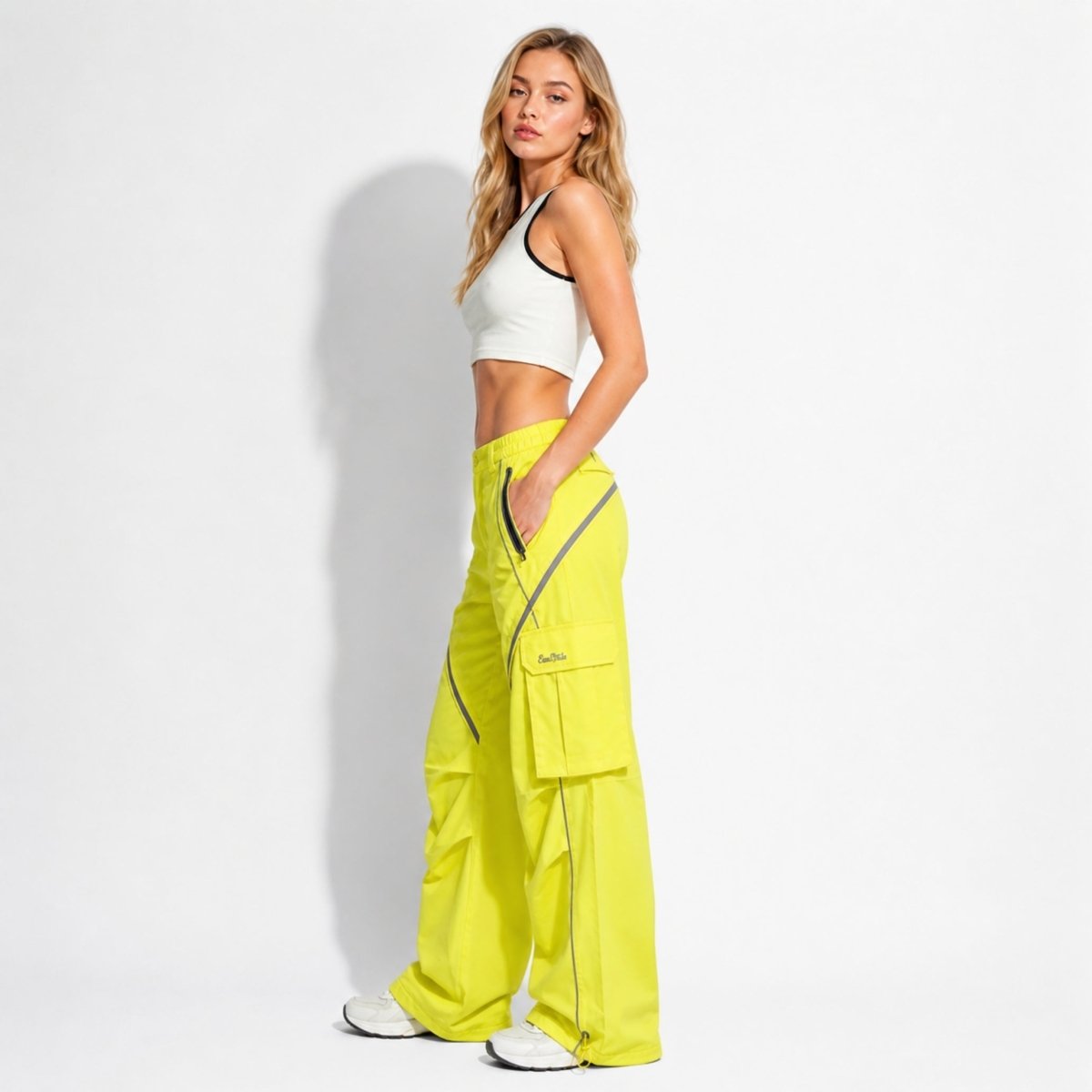 Side profile of neon yellow wide leg cargo pants highlighting flap pockets, reflective lines, and relaxed fit