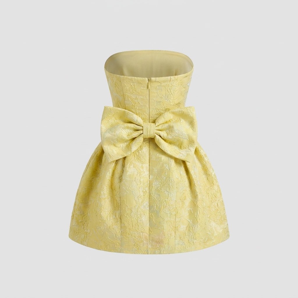 Back ghost mannequin product view of the yellow strapless dress highlighting the large back bow detail